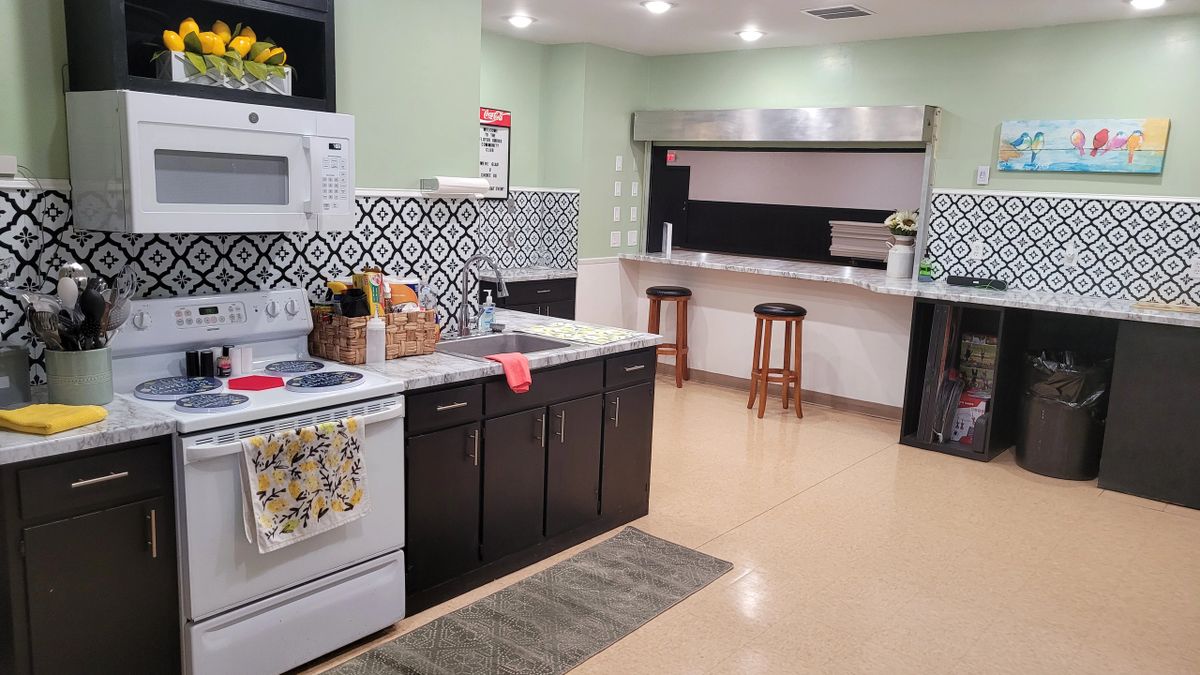 The full service kitchen with stove, refrigerators, and serving window