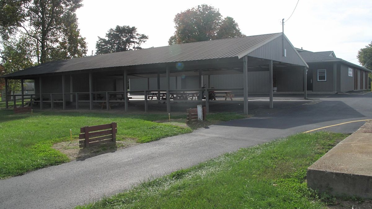 The covered outdoor shelter house with picnic tables